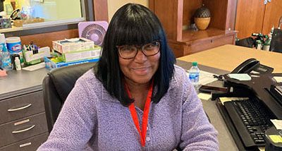Pat, a family ambassador volunteer at Aurora House welcome desk