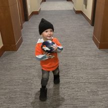 son playing with his football in the hall before Broncos game